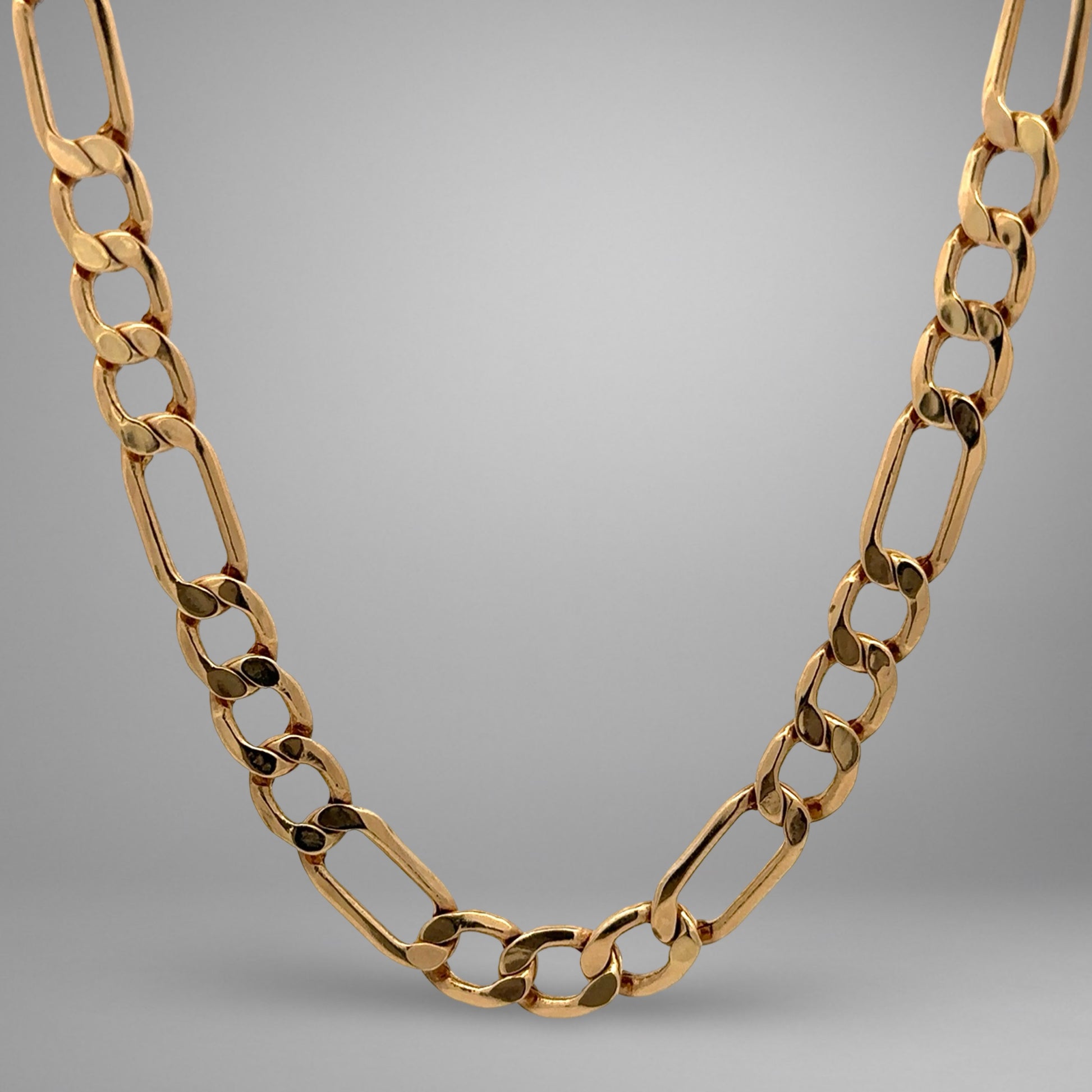 Gold chain necklace on a gray background