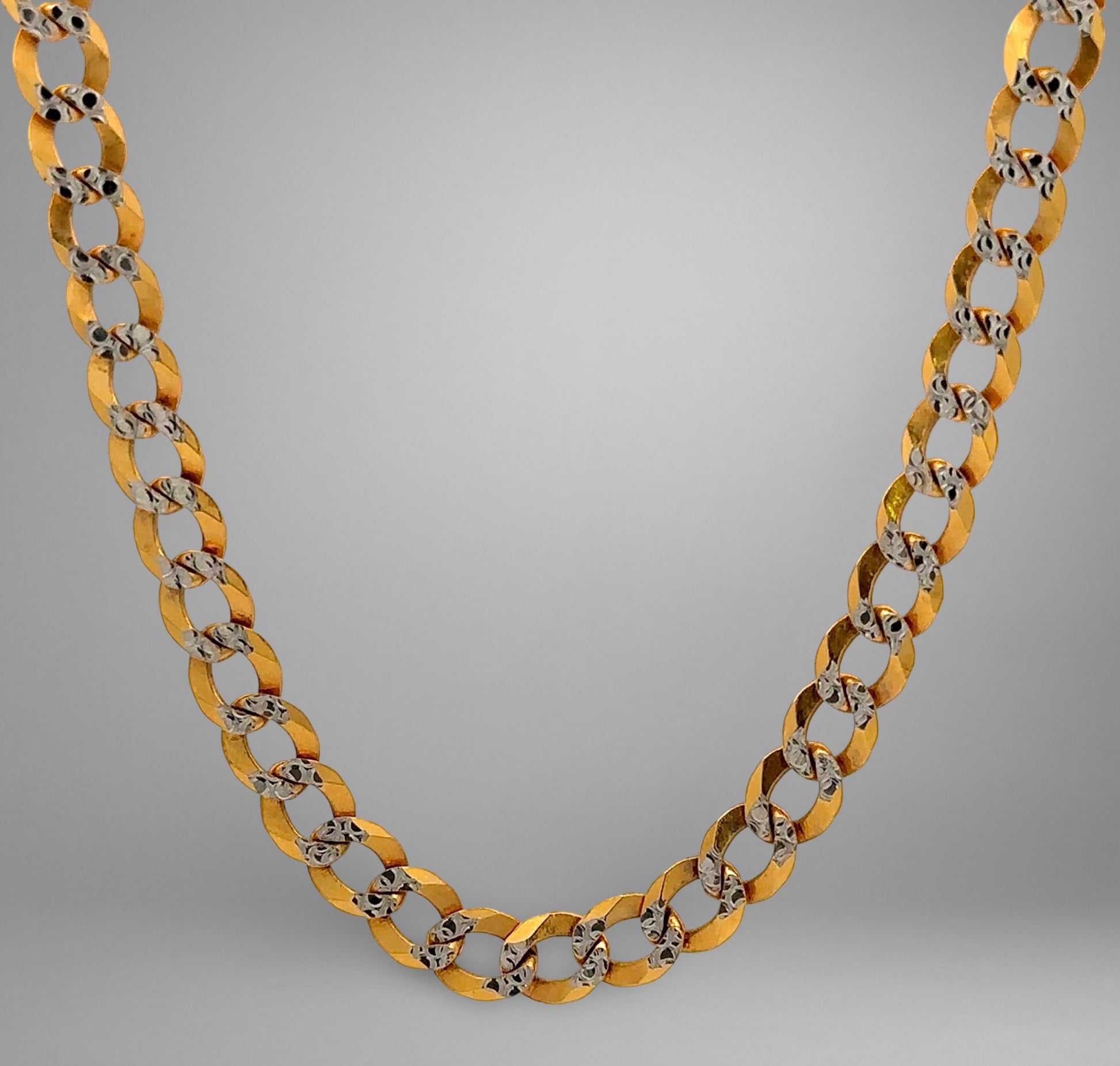Gold chain necklace on a gray background