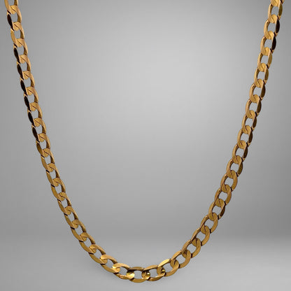 Gold chain necklace on a gray background
