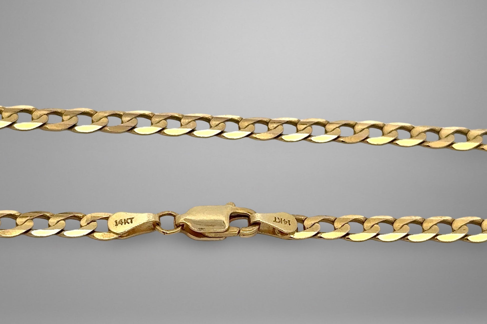 Gold chain with a clasp on a gray background