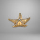 Gold starfish-shaped jewelry with embedded stones on a gray background