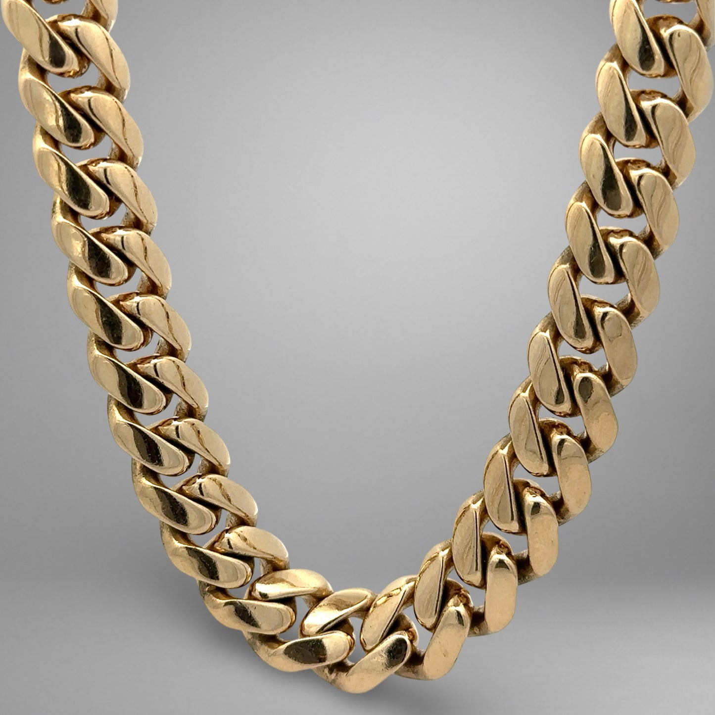 Gold chain necklace on a gradient gray background