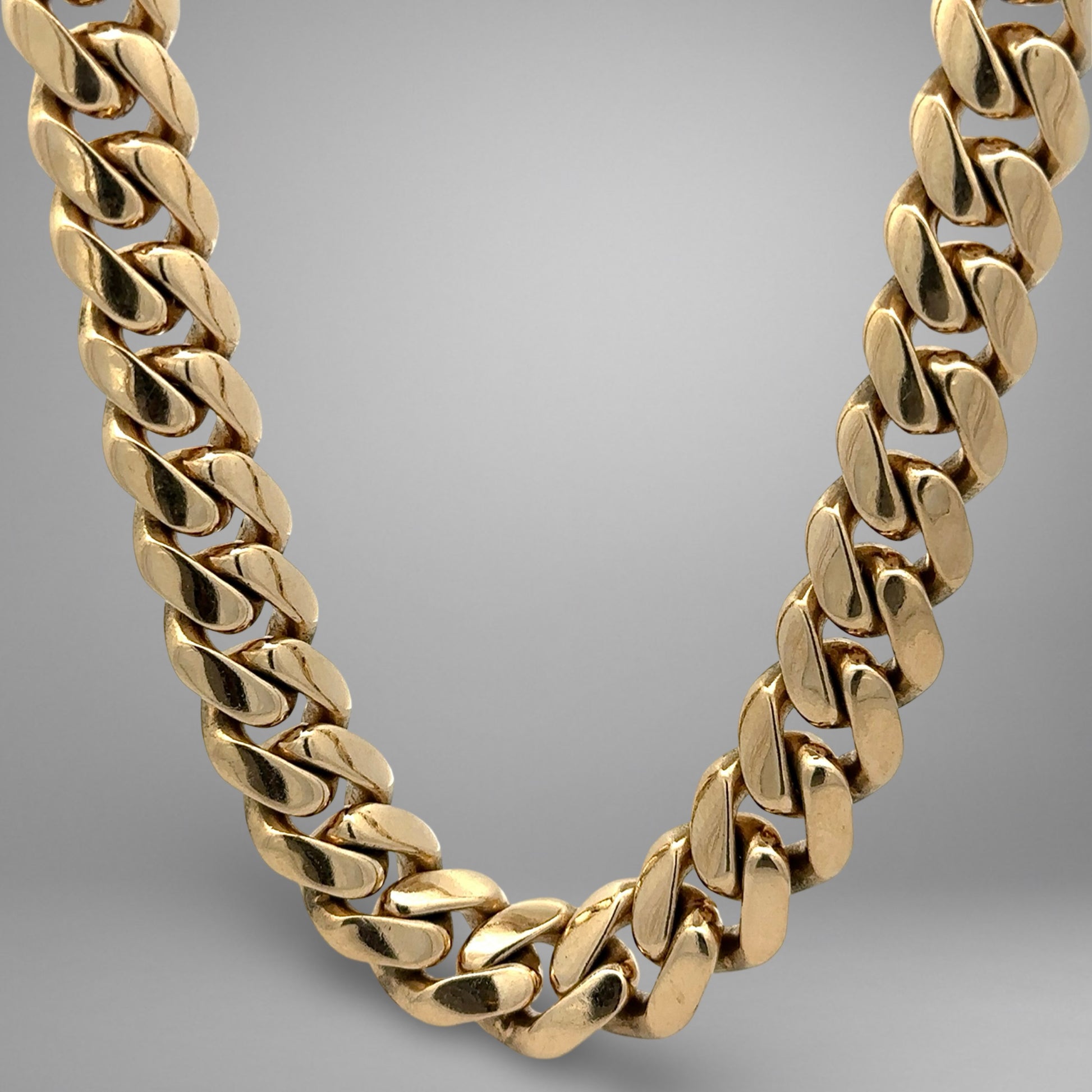 Gold chain necklace on a gradient gray background