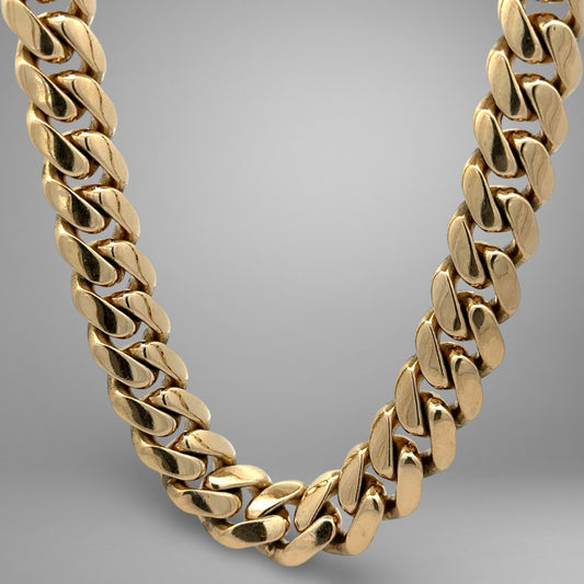 Gold chain necklace on a gradient gray background