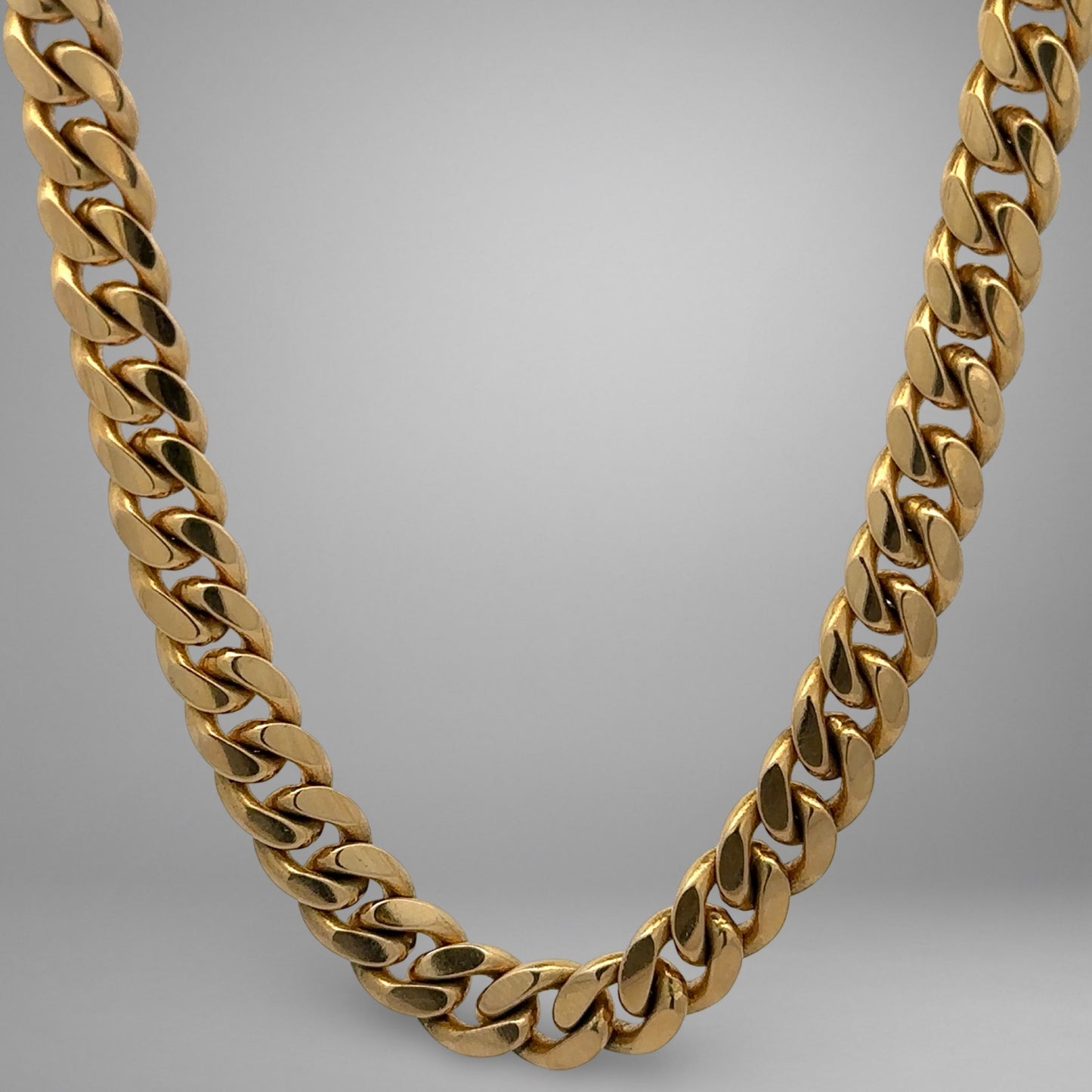 Gold chain necklace on a gray background