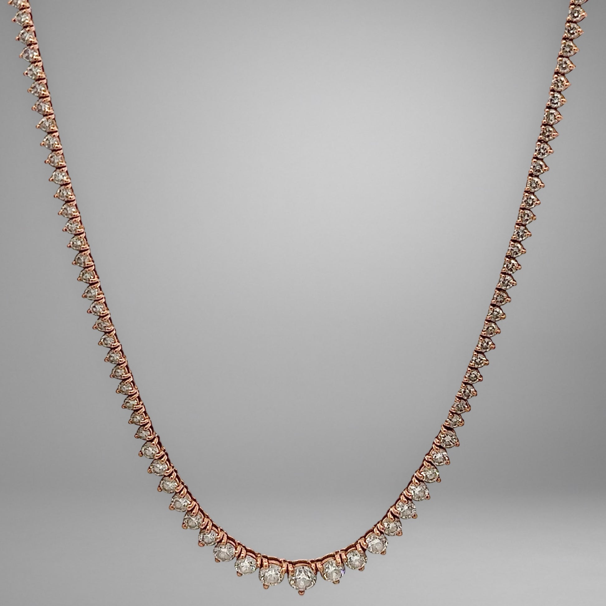 Rose gold necklace with diamonds on a gray background