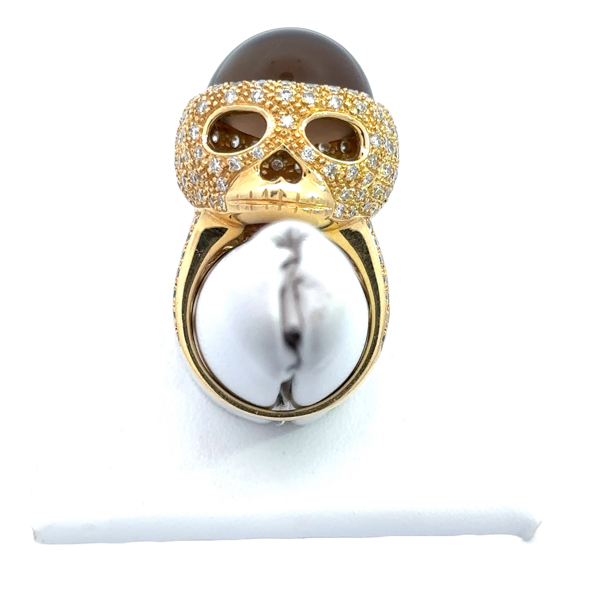 The skull ring on a ring stand to show what it would look like on the finger.