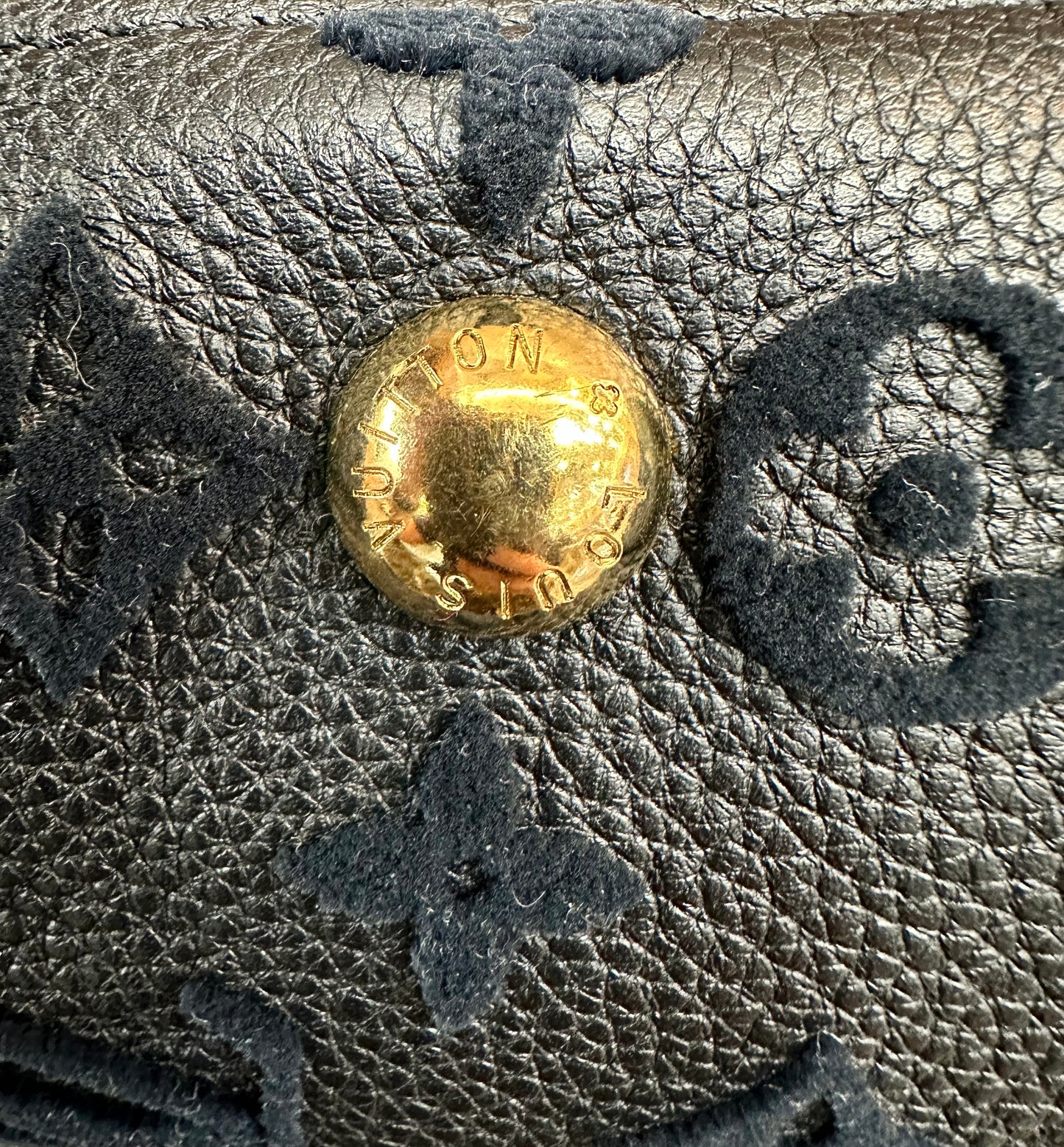 Scratches on gold buttons on bottom of bag