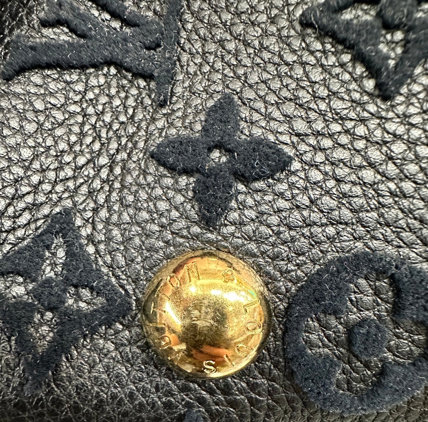 Scratches on gold button on bottom of bag