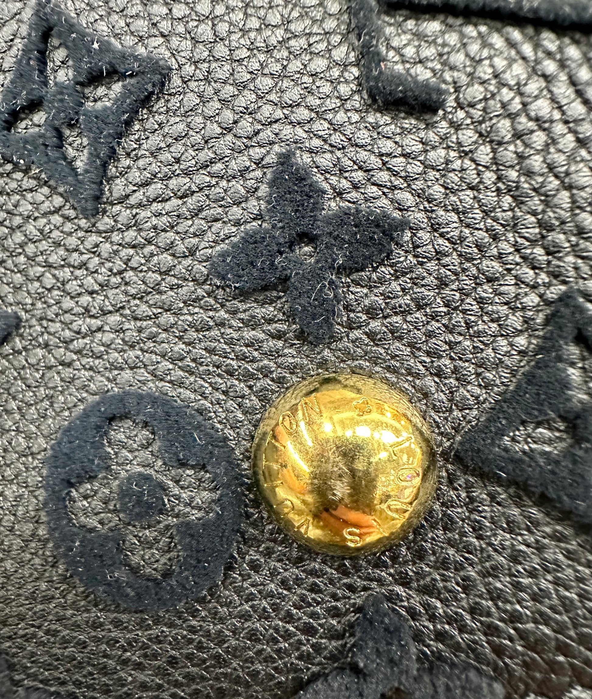 Scratches on gold button on bottom of bag