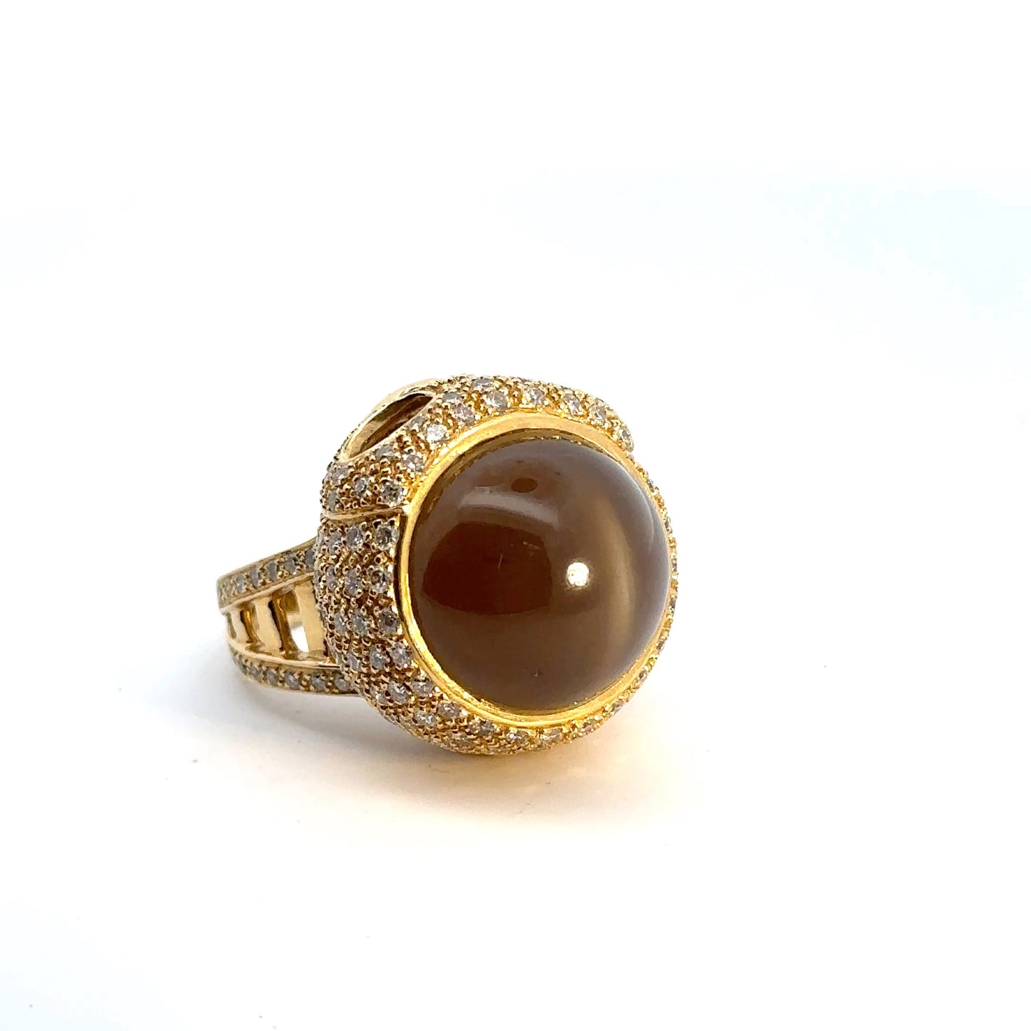 The cat's eye effect on the top of the brown stone. This gemstone has a white line across the top when a light is shown on it.