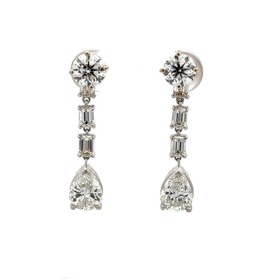 Diamond drop earrings with 1 carat round diamond at top, 2 .20 carat emerald cut diamonds below, + 1 .75 carat pear shaped diamonds at bottom