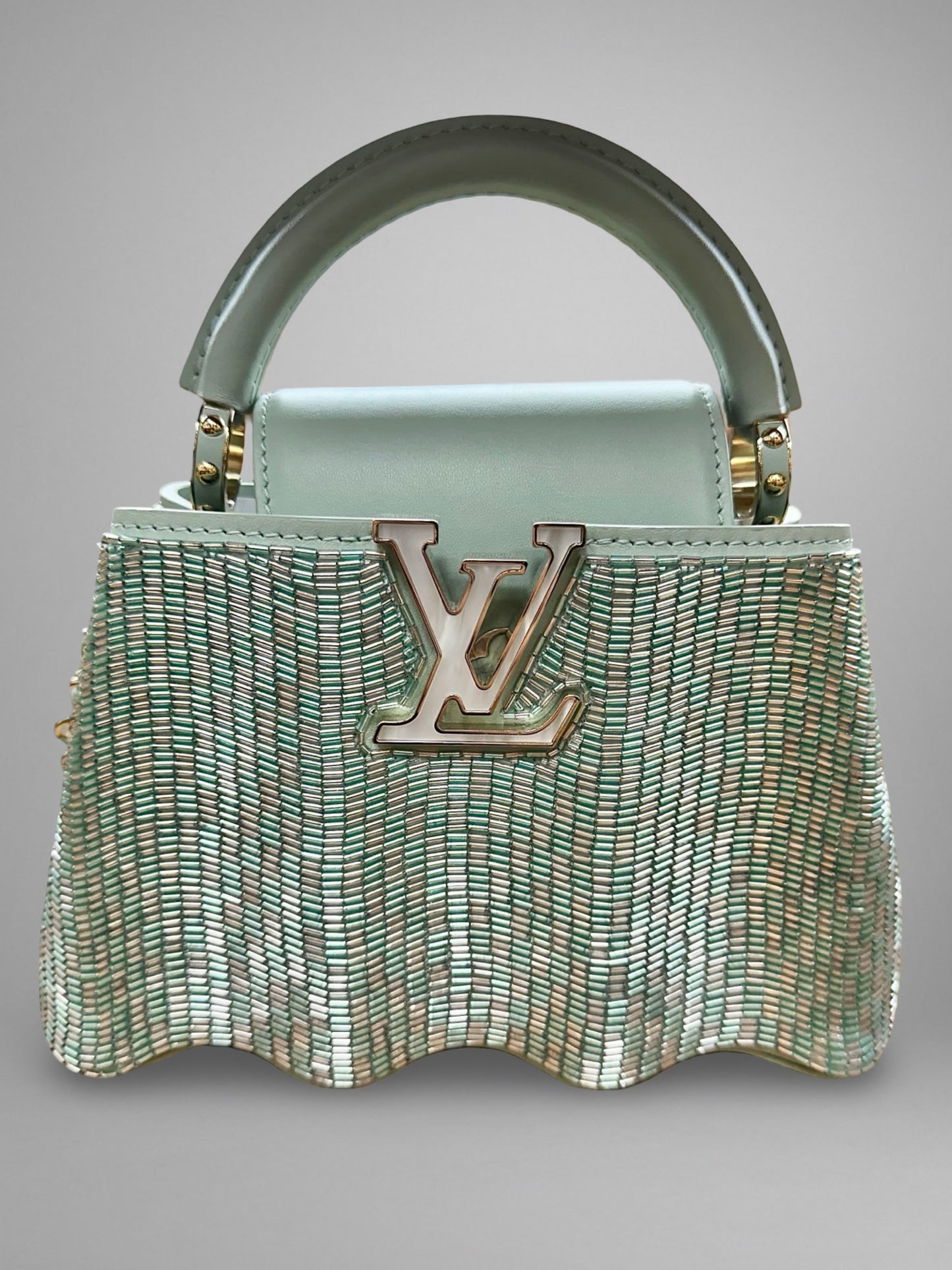 Designer handbag with a prominent brand logo on a gray background