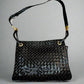 Black patent leather woven texture bag with gold hardware and misshaped shoulder strap