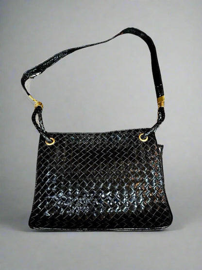 Black patent leather woven texture bag with gold hardware and misshaped shoulder strap
