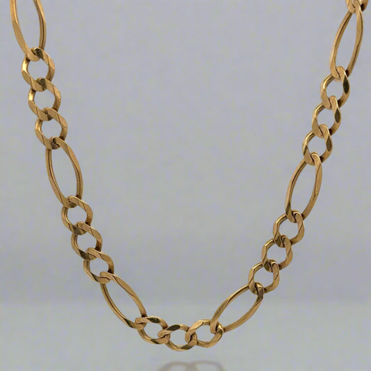 Front of Figaro style link chain in yellow gold