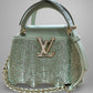 Light blue handbag with chain detail and visible brand logo on a gray background