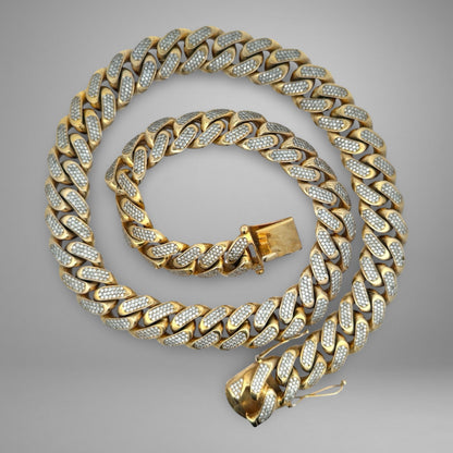 Gold chain with diamond accents on a gray background