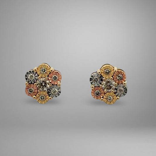 Pair of floral earrings with gold, rose gold, and silver colors on a gray background