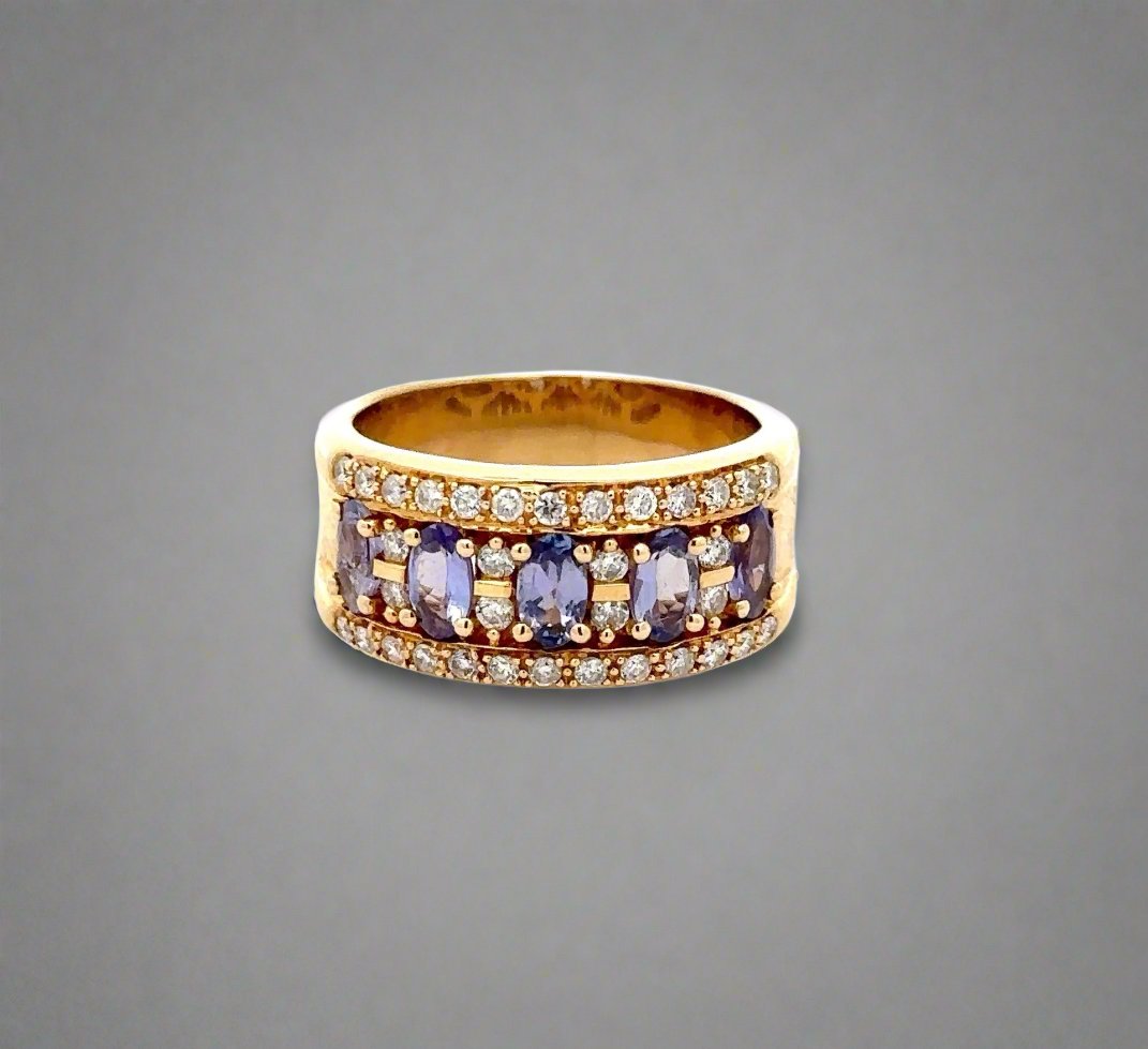 Yellow gold band with small round diamonds and 5 oval shaped light blueish-purple colored gemstones