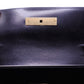 Inside flap of YSL black handbag with gold hardware + straps to hold the shoulder strap