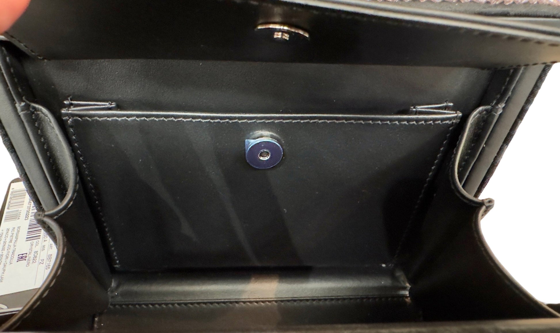 Open black flap inside with plastic on button