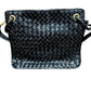 Front of black patent leather bag with woven texture