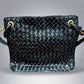 Front of black patent leather bag with woven texture