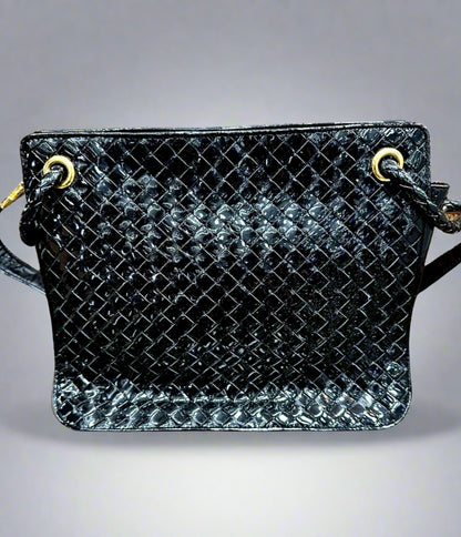 Front of black patent leather bag with woven texture