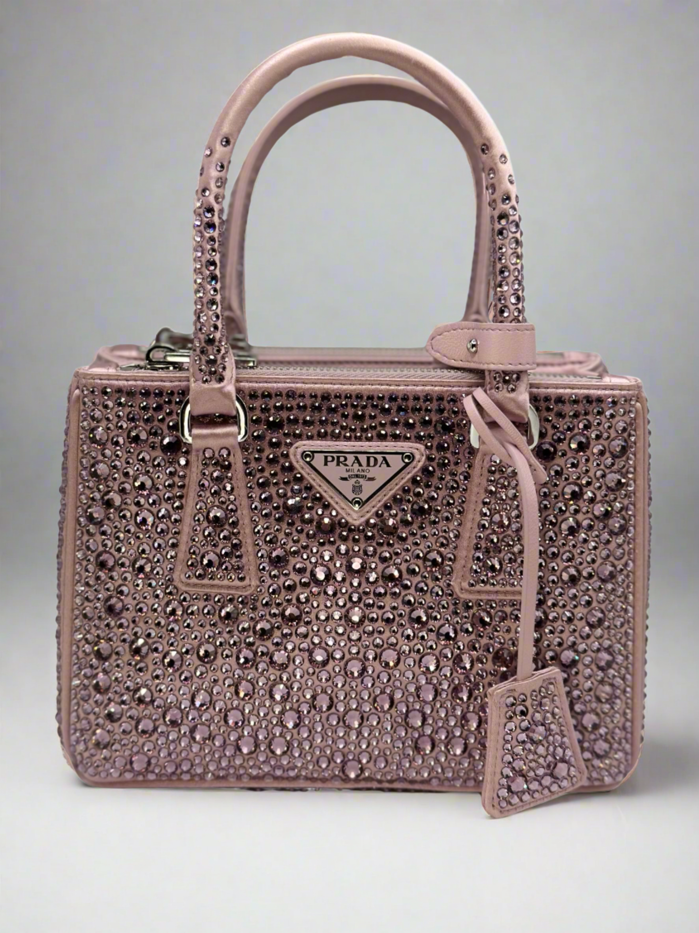 Pictured: The front of the Prada Galleria Crystal mini satin bag in pink covered with pink crystals. No imperfections.