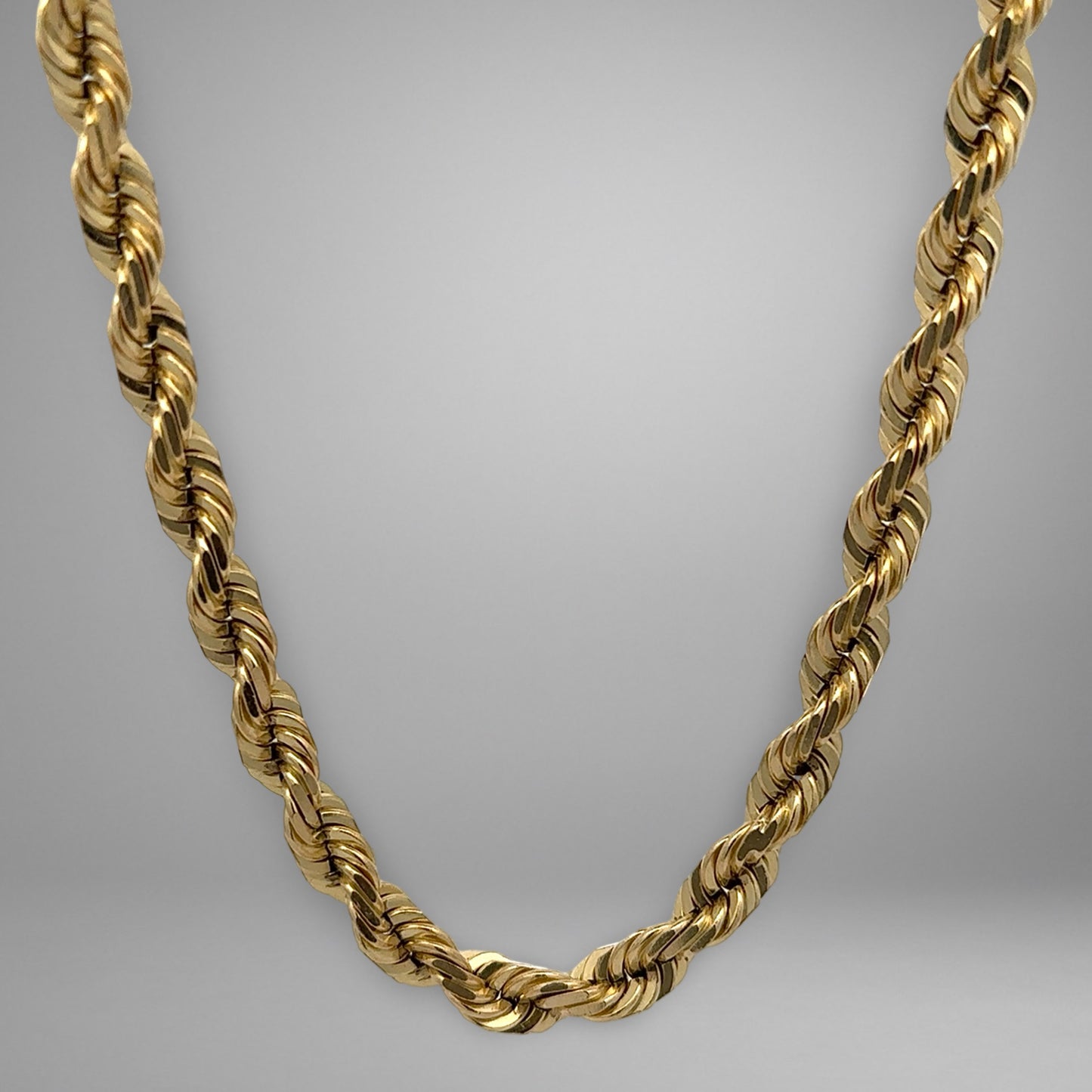 Gold rope chain on a gray background