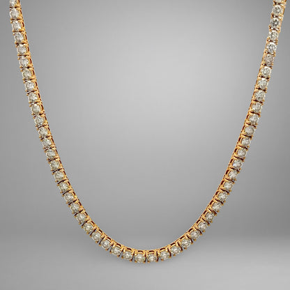 Gold necklace with diamonds on a gray background