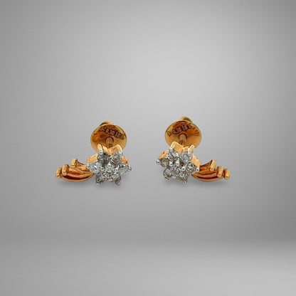 Pair of gold and diamond earrings on a gray background