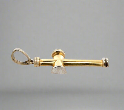Side of yellow and white gold cross with scratches and marks on gold. Round bail