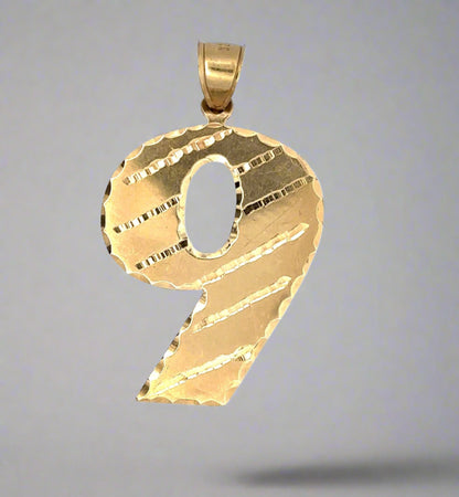 Front of yellow gold 9 pendant showing scratches on gold from handling