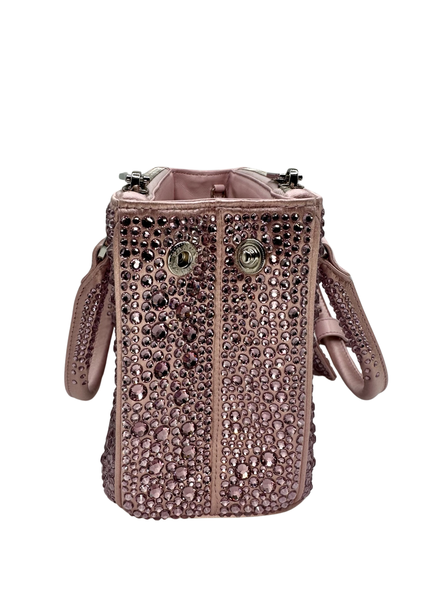 Pictured: The right side of the Prada Galleria Crystal mini satin bag in pink covered with pink crystals. It has 2 buttons on the side to close the bag. No imperfections.