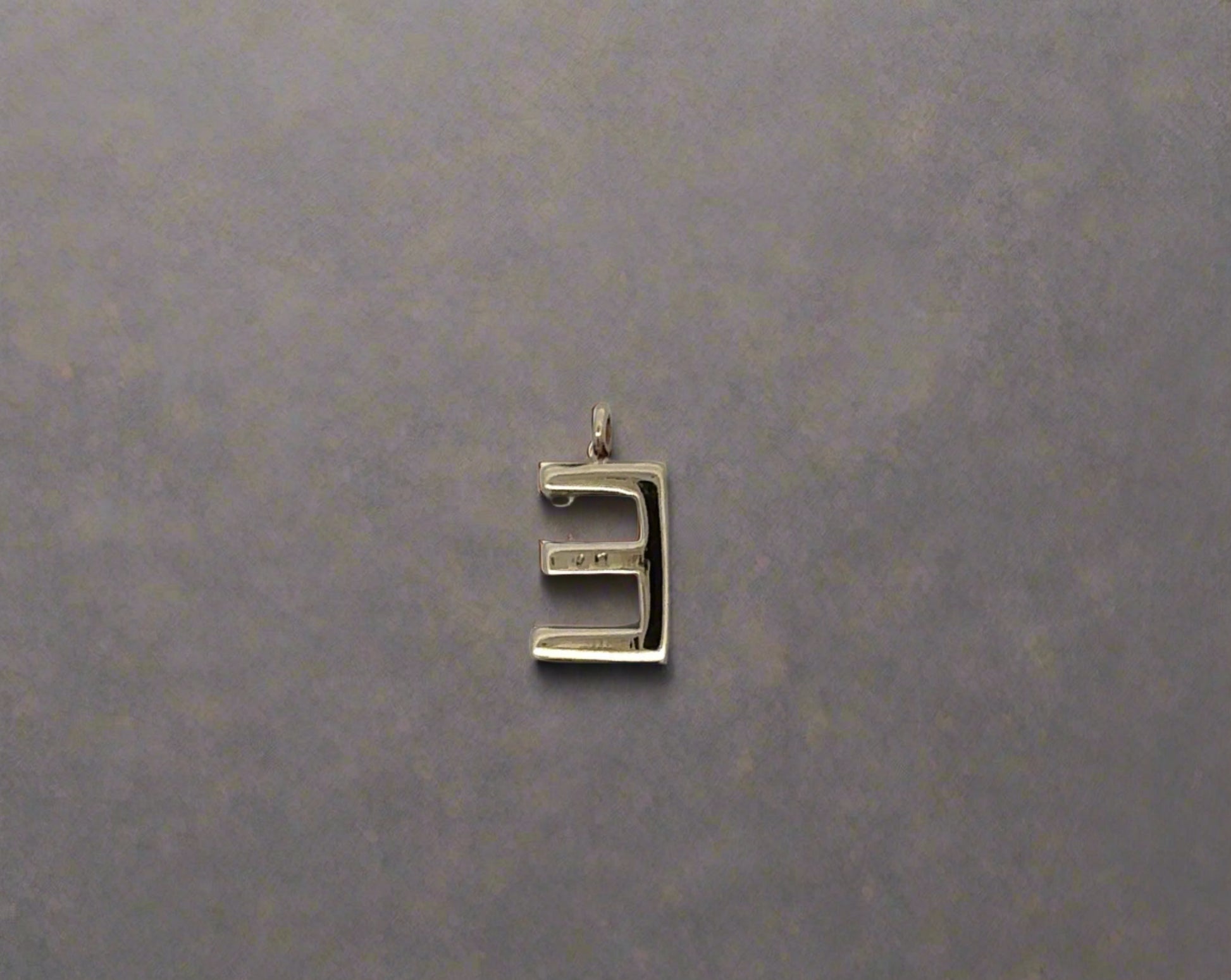 Back of E pendant with marks on back