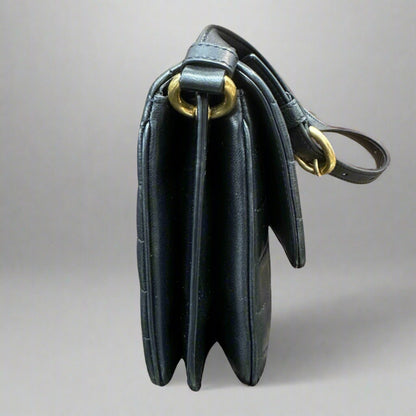 Side of black quilted bag and gold hardware