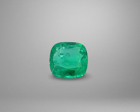Cushion-shaped emerald on a gray background