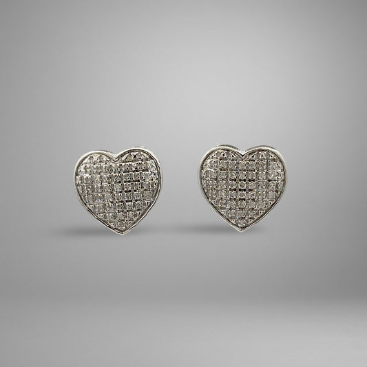 Heart-shaped white gold earrings on a gray background