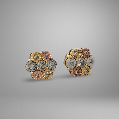 Pair of tri color gold floral earrings on a gray background