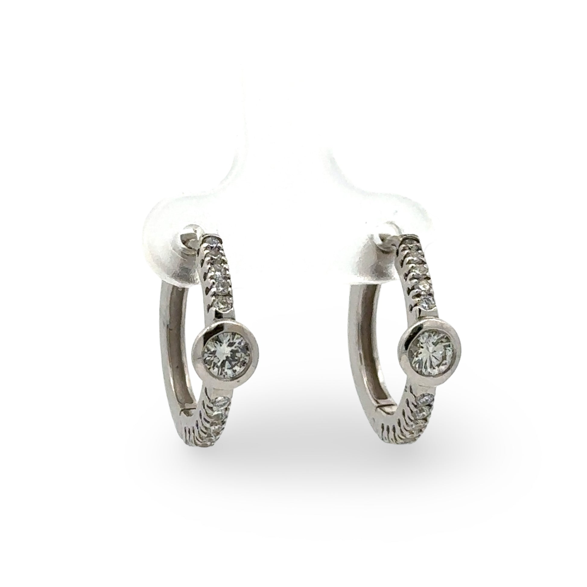 Pair of white gold diamond hoop earrings  on a white background