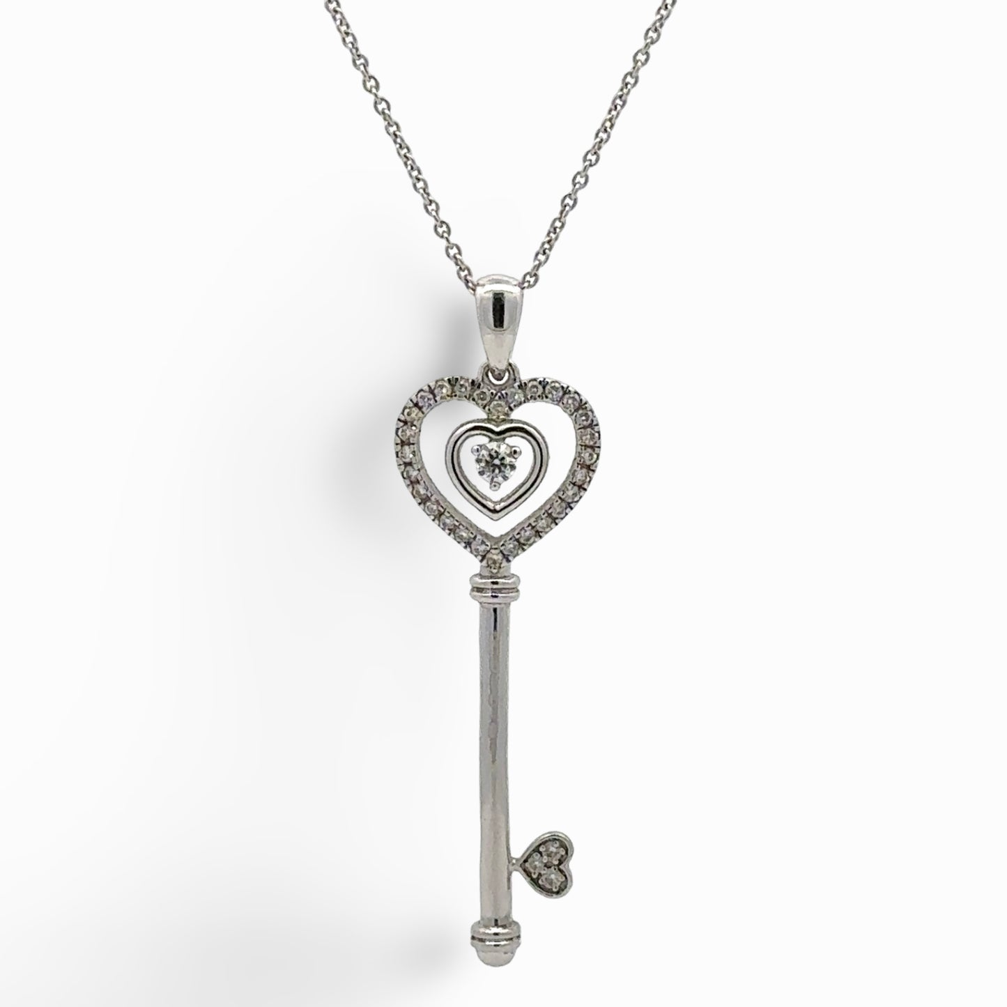 white gold key shaped pendant on a thin chain with attached hearts