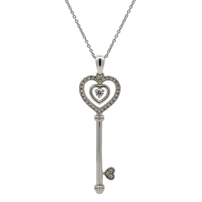 white gold key shaped pendant on a thin chain with attached hearts