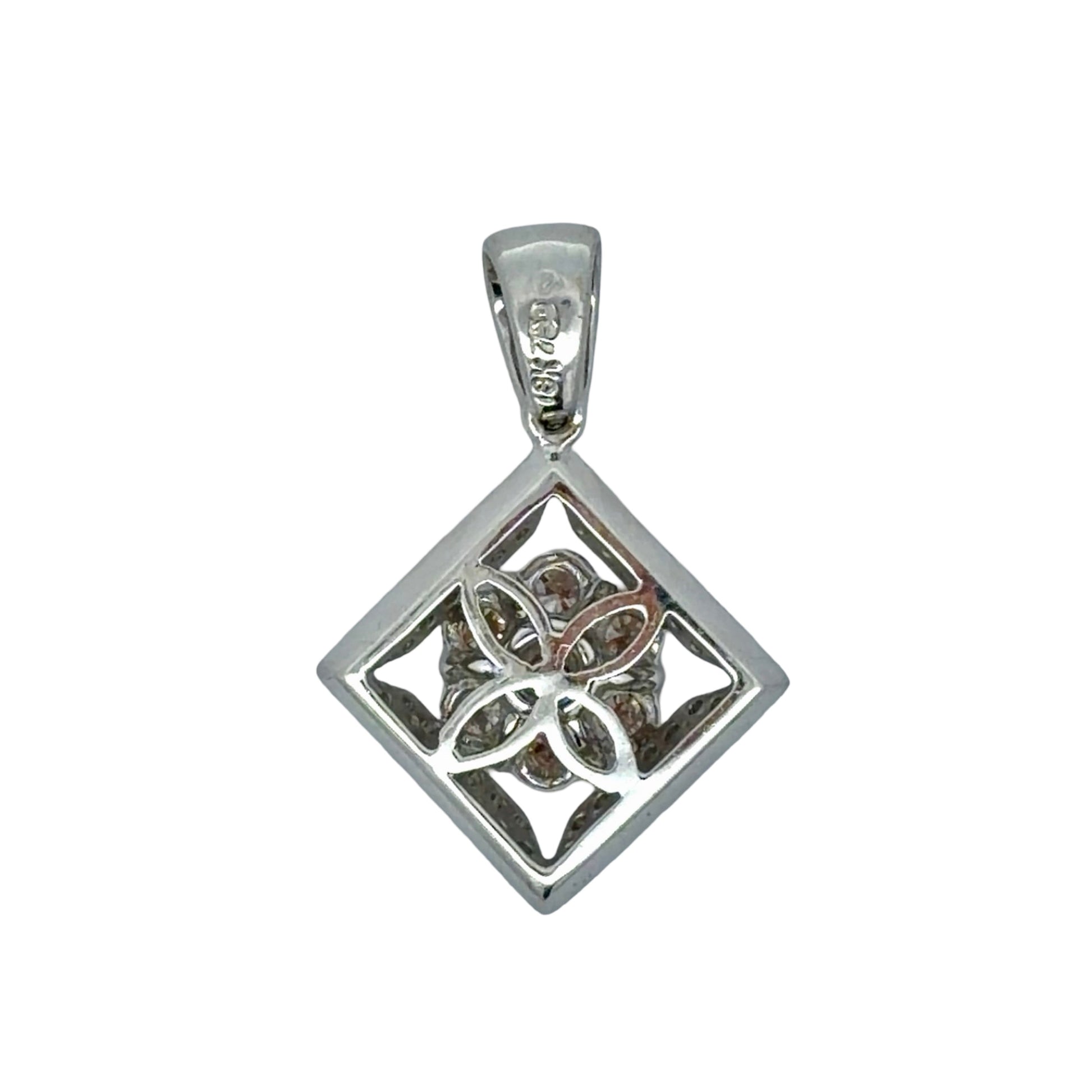 Back of white gold pendant with floral design and 18K stamp