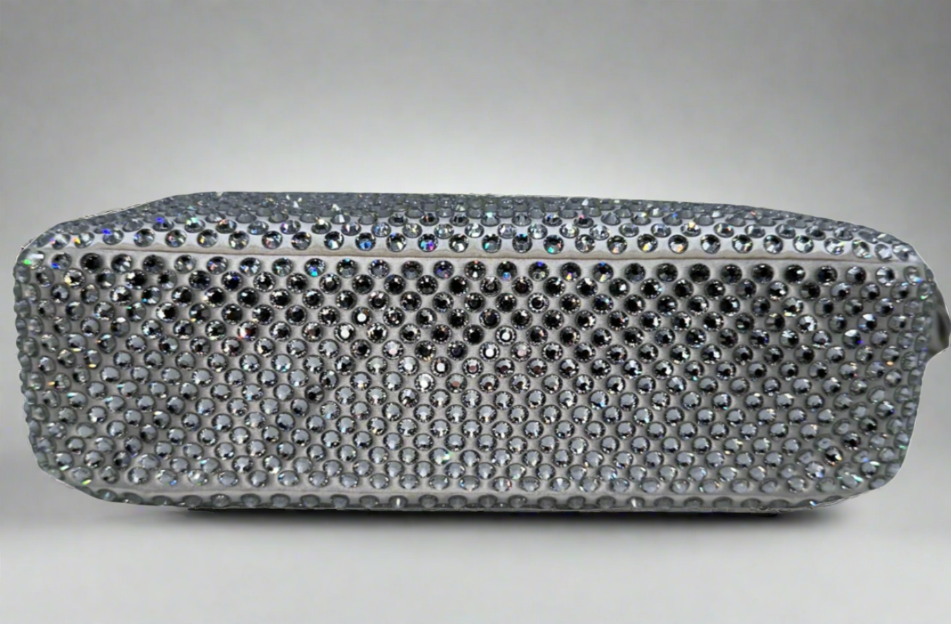 Pictured: The bottom of the Prada Crystal satin mini bag re-edition in white covered with crystals. No imperfections.