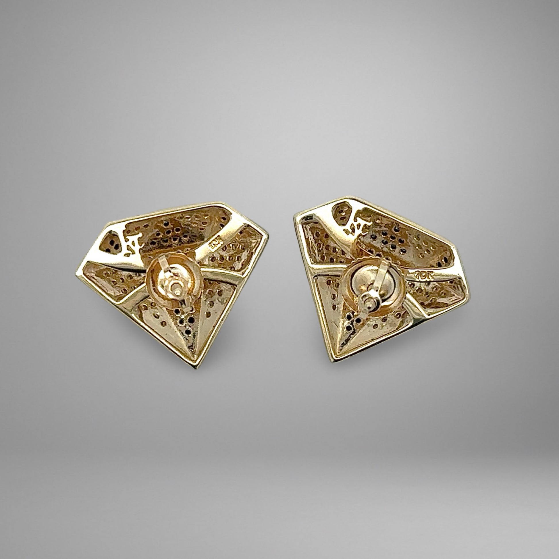 Pair of gold earrings on a gray background with 10K stamp on the back