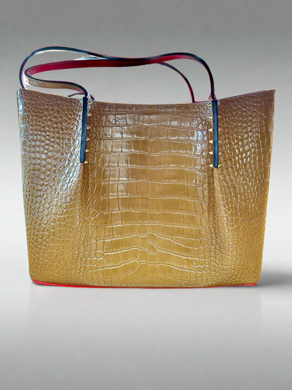 Back of large brown tote bag with gold spike detailing and crocodile-like details.