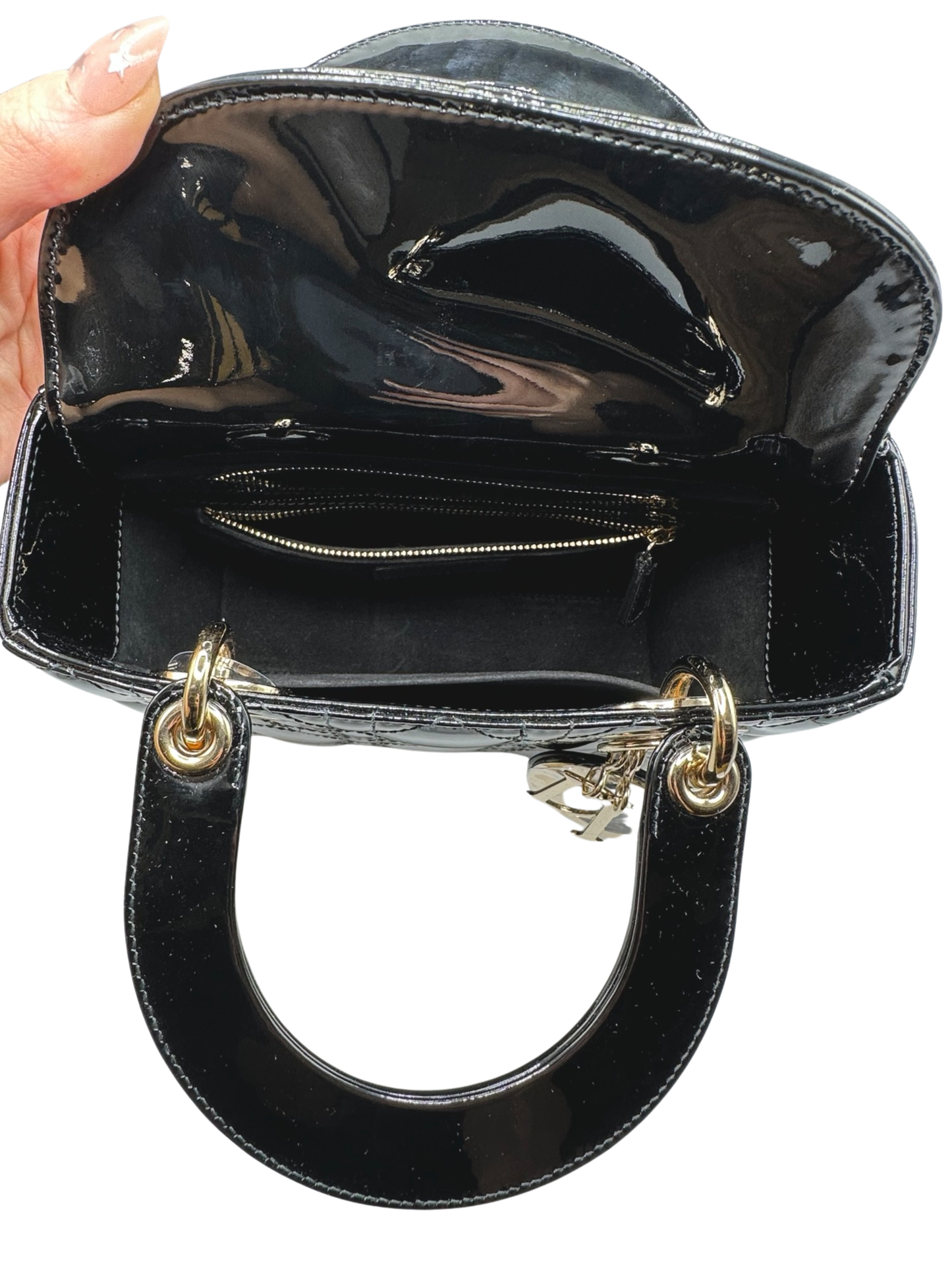 Top of small lady dior black patent leather bag with the flap open
