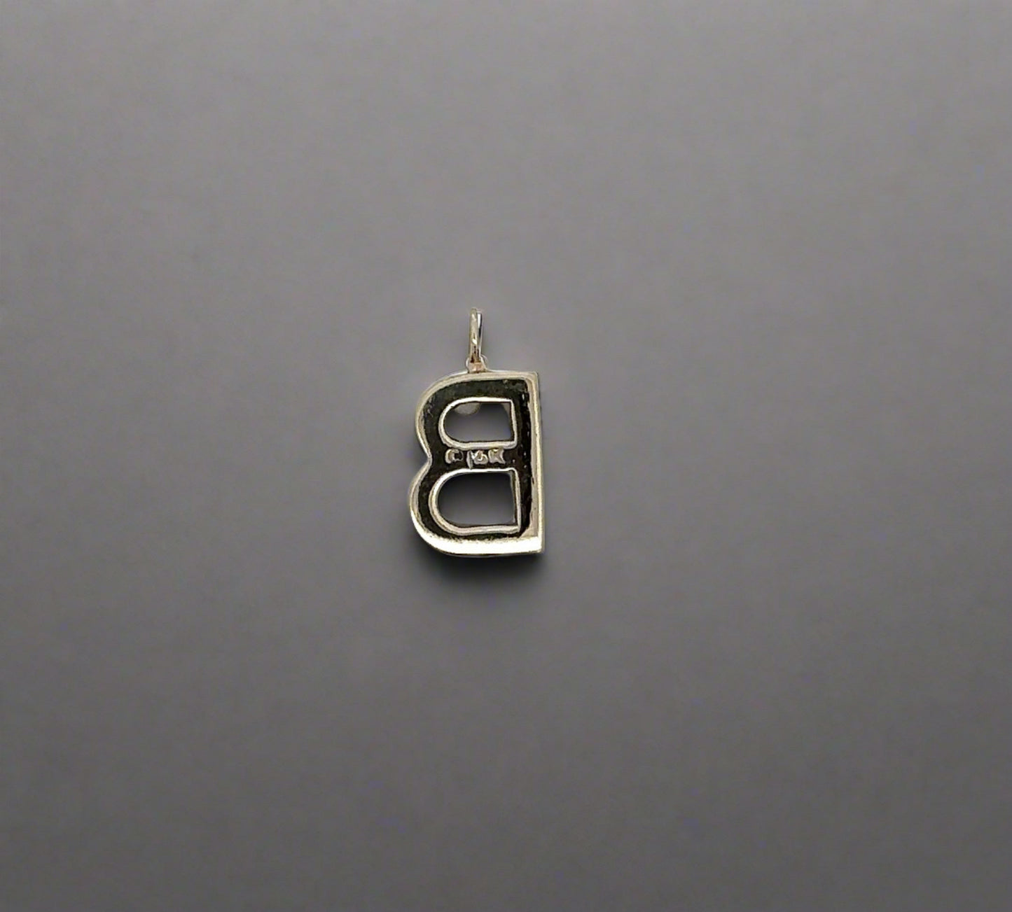 Back of pendant with 14K stamp and mark on gold